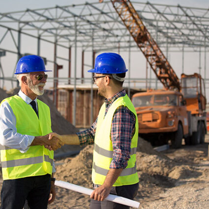 Engineers shaking hands on construction site Quality